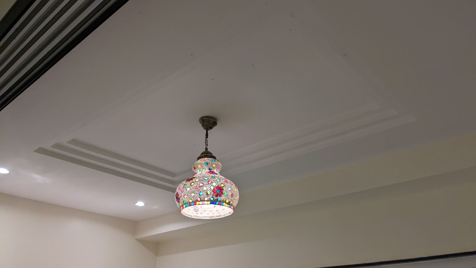 Mosaic glass pendant light set into a tray ceiling