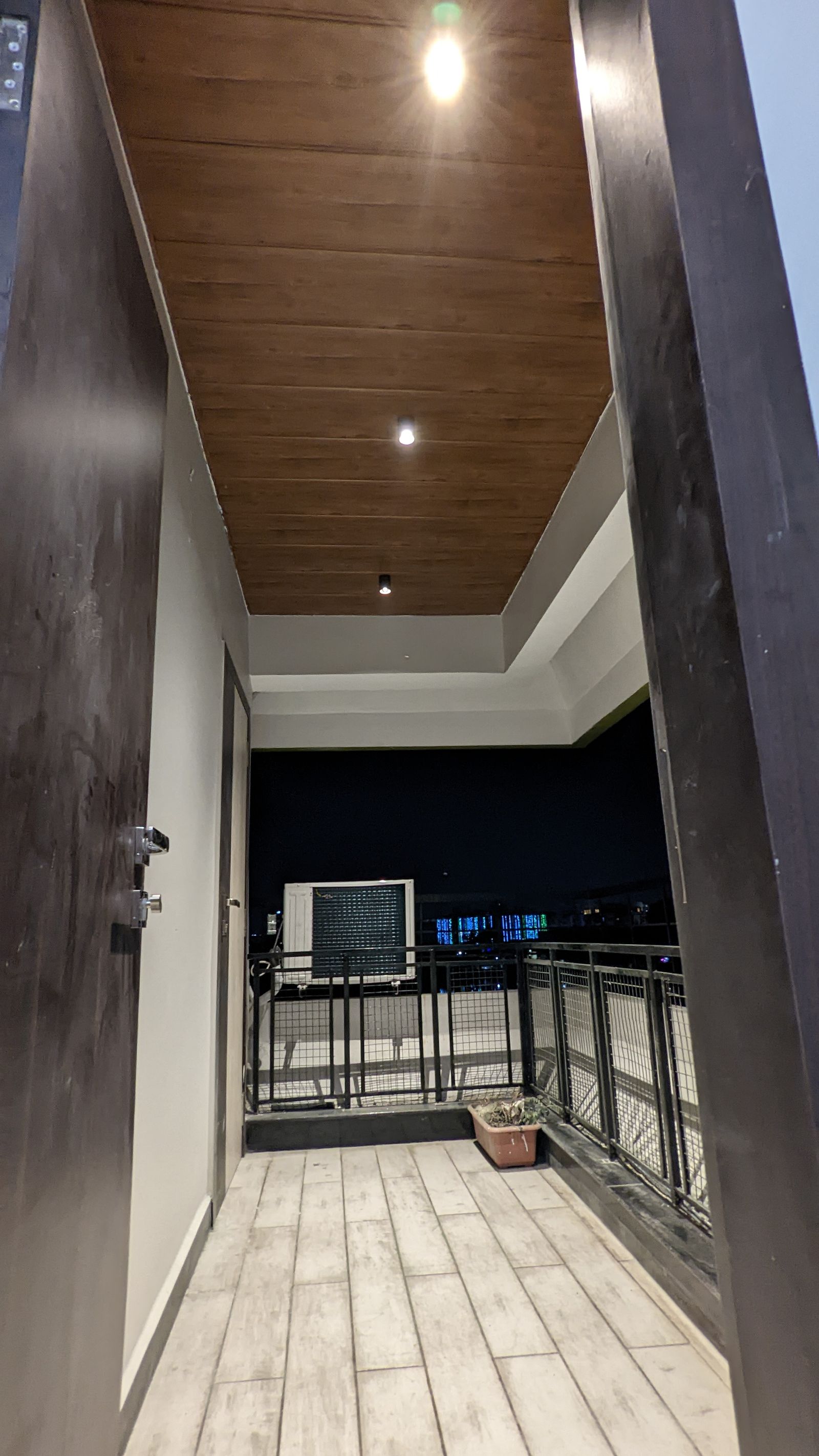 Covered terrace walkway with a wood-clad ceiling, night view