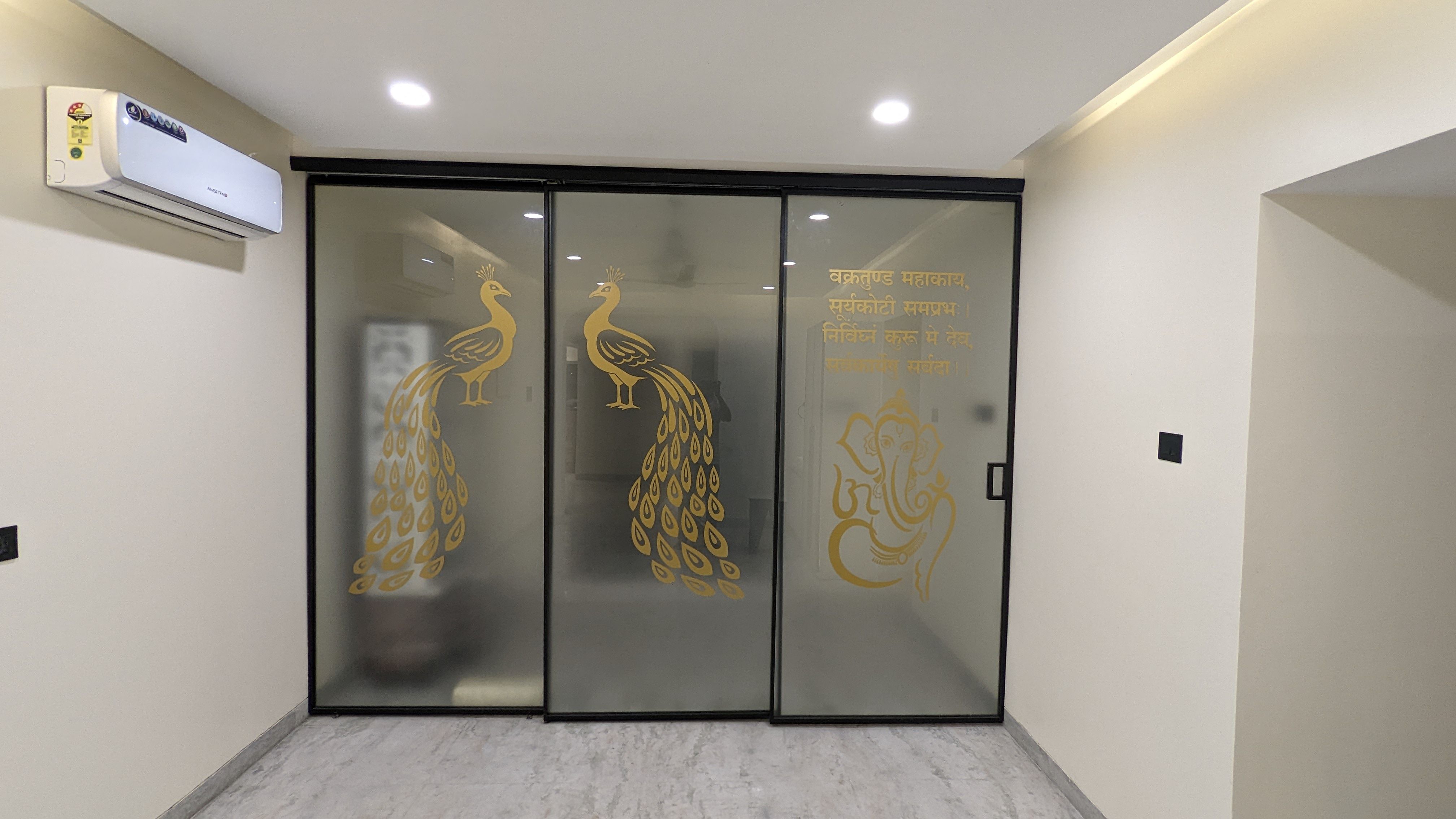 Sliding glass doors etched with a gold peacock and Ganesh motif